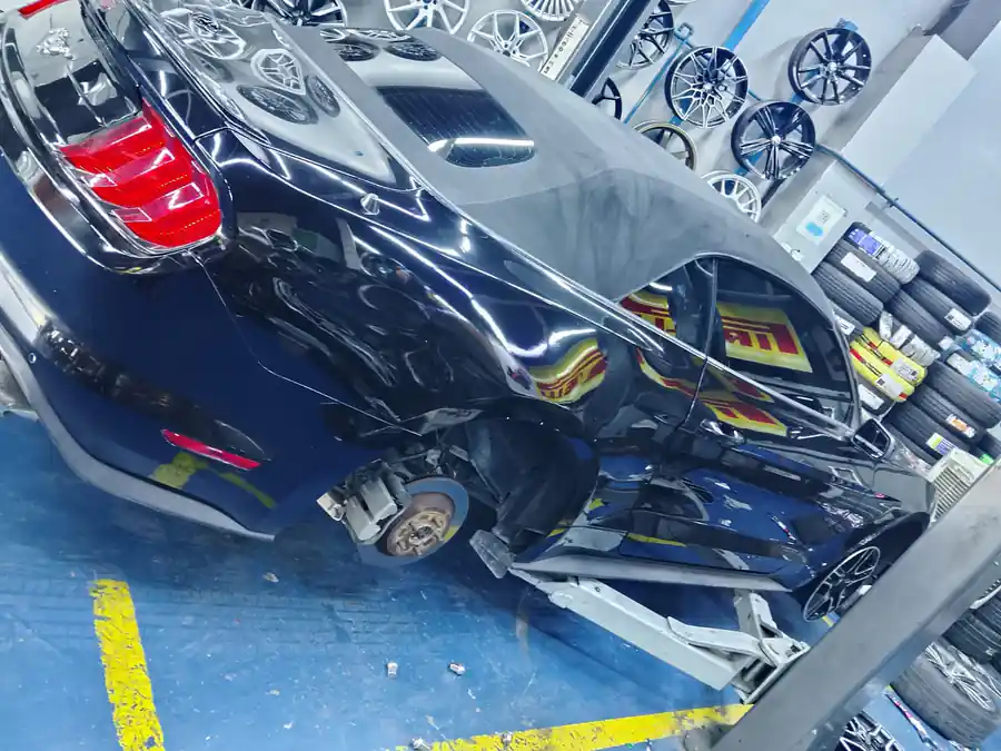 Technician working under the hood of a Nissan sedan